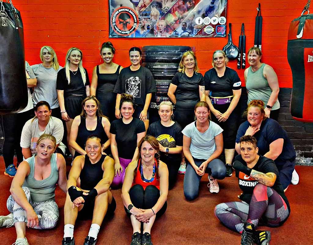 Image 8 – Large boxing class group Alternative Text: Group of athletes attending boxing fitness class