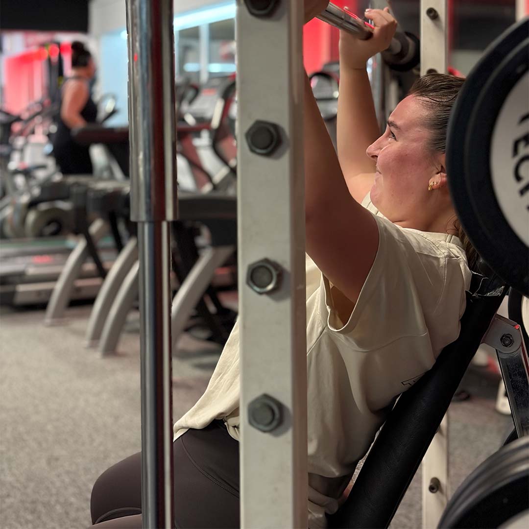 Member performing barbell bench press