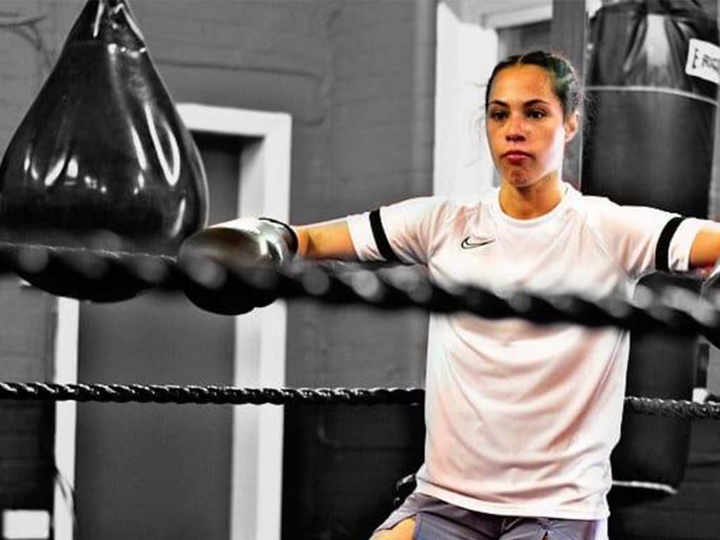 Female boxer training in boxing ring