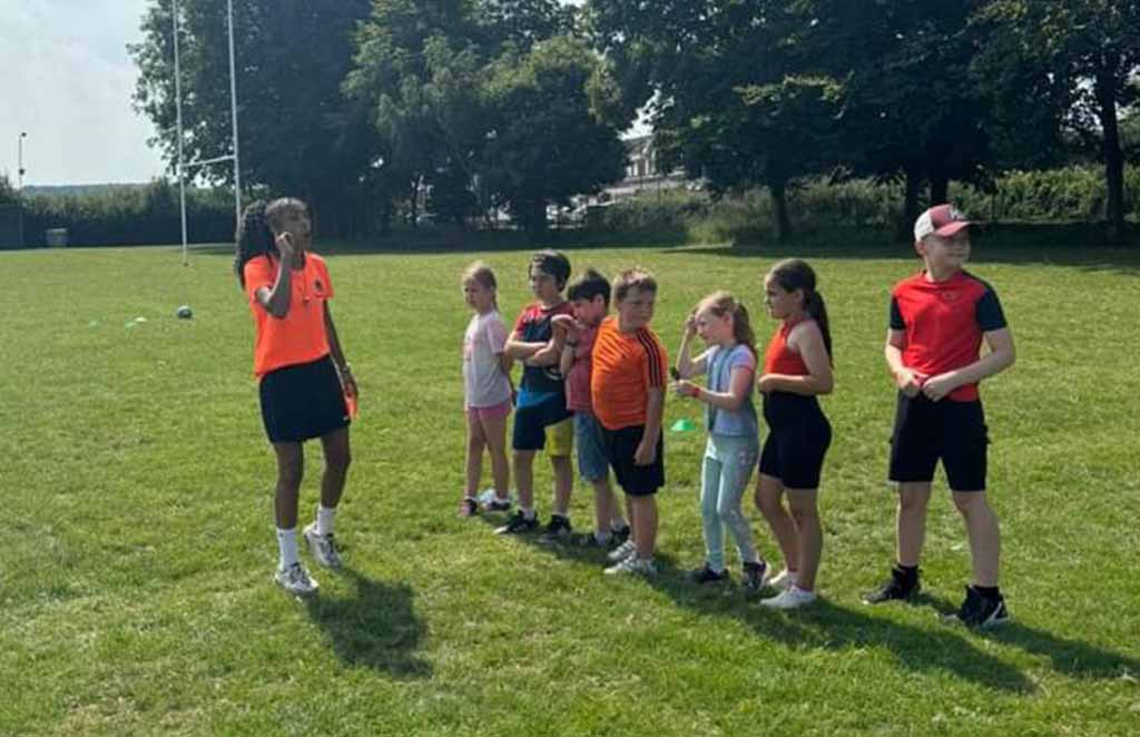 Children lined up during outdoor sports coaching session