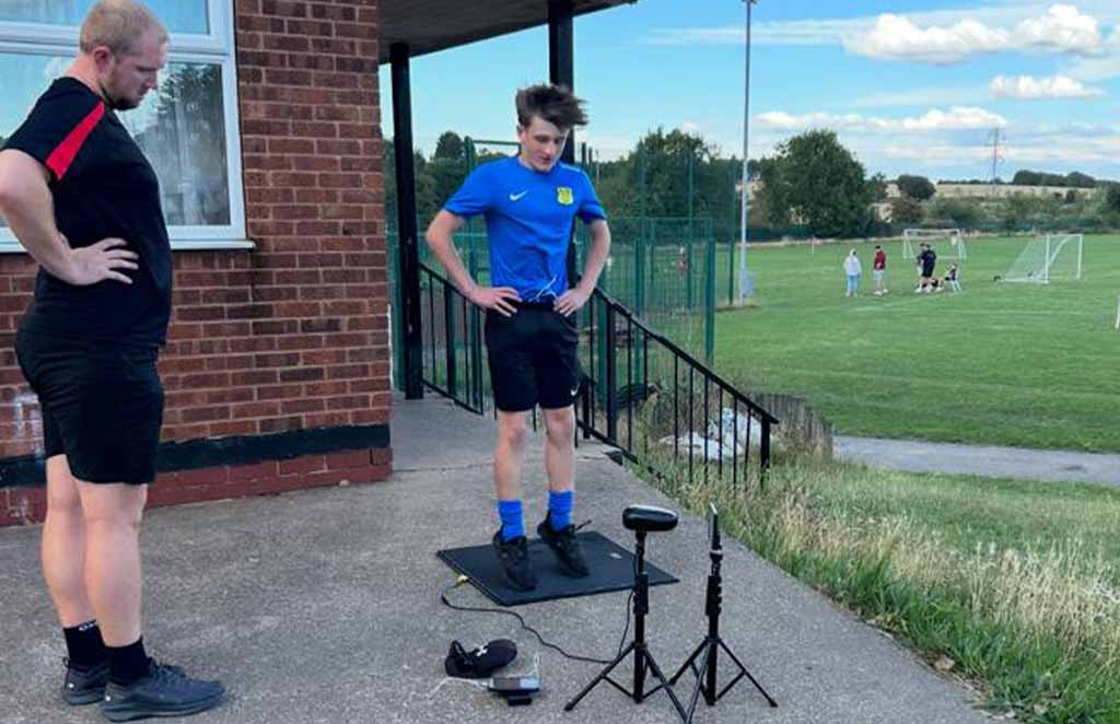 Athlete performing outdoor vertical jump test with measuring equipment