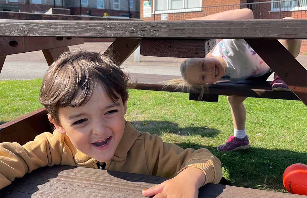 Child completing outdoor obstacle during kids activity session