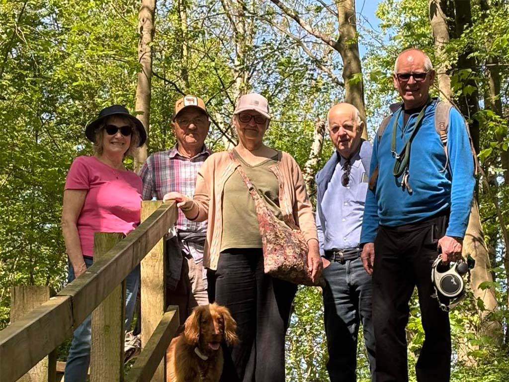 Community walking group with dog outdoors