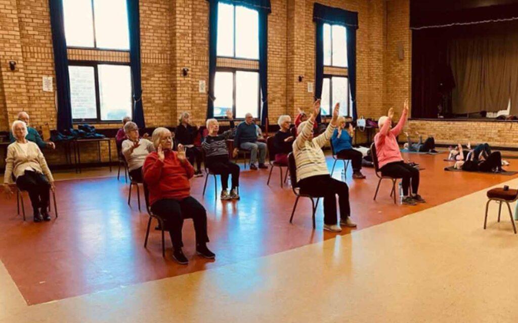 Seated group exercise class in community hall
