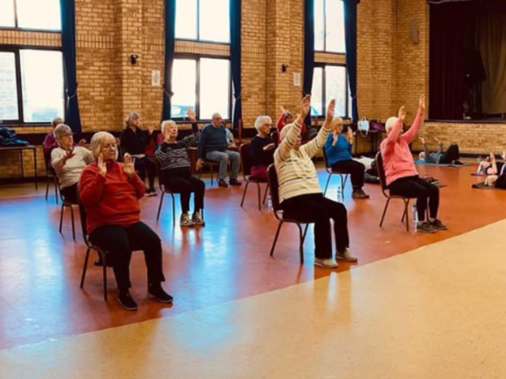 Group seated fitness class in local hall