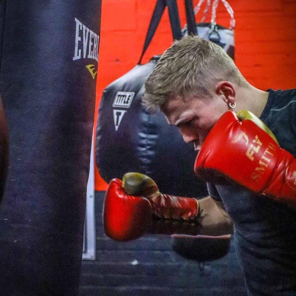 Young boxer training on heavy bag at Lync Active boxing gym