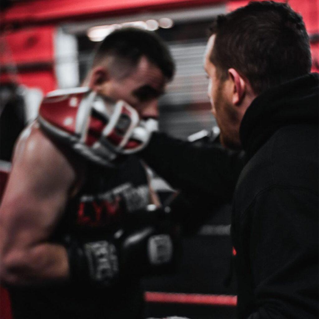 Boxer practising pad work with coach at Lync Active boxing gym