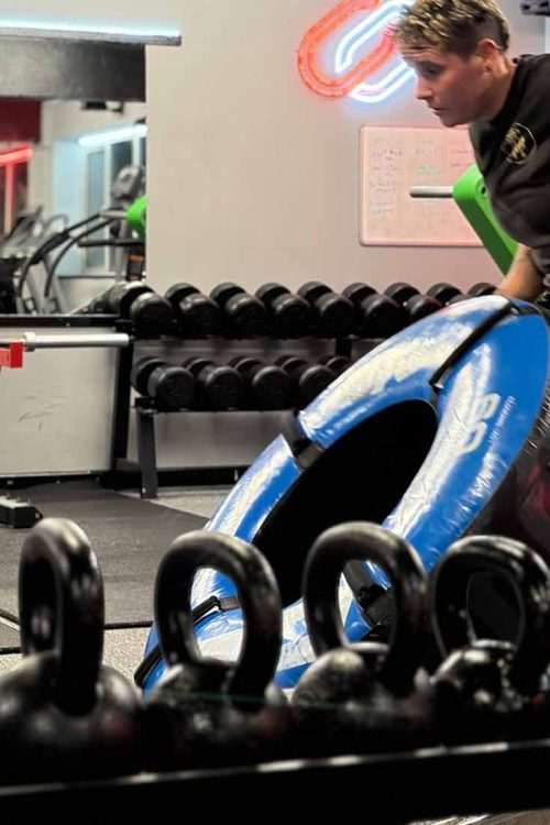 Member performing kettlebell exercise in gym