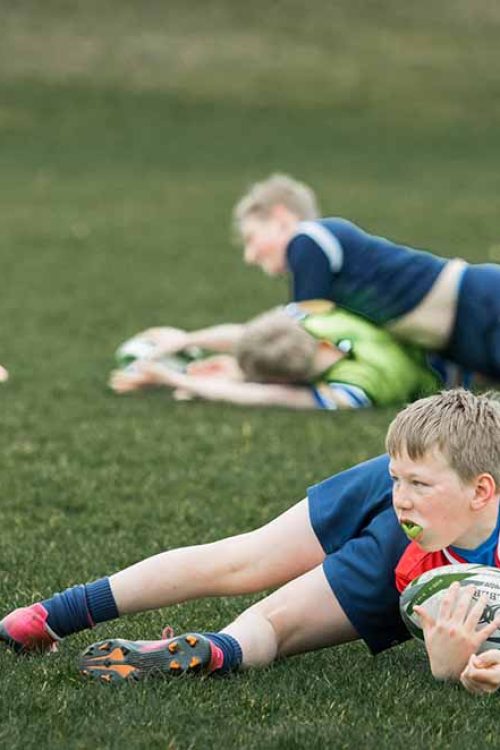 Young rugby players practising tackling during training session