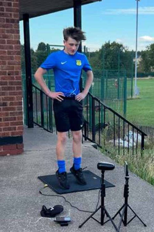 Athlete performing outdoor vertical jump test with measuring equipment